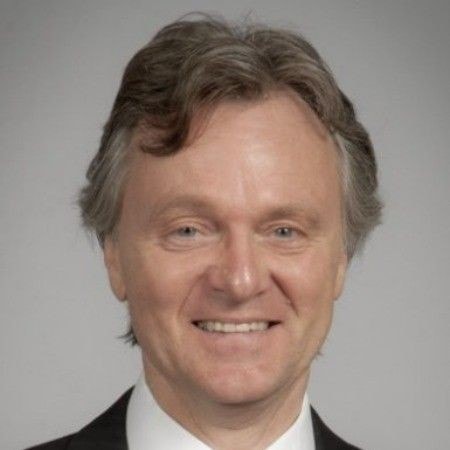 Portrait d'un homme professionnel souriant, représentant la confiance et l'expertise.